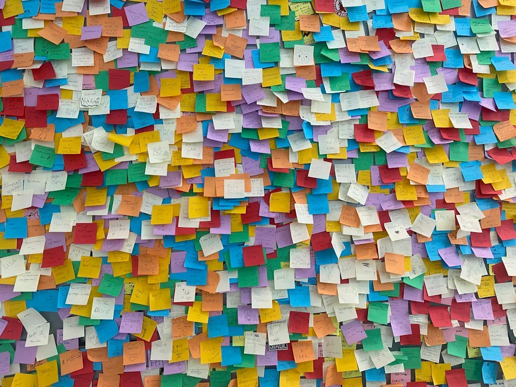 Bright and colorful sticky notes plastered on a wall, symbolizing creativity and brainstorming.